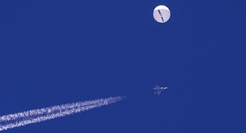 A large balloon drifts above the Atlantic Ocean, just off the coast of South Carolina, with a fighter jet and its contrail seen below it. ( File Photo | AP)