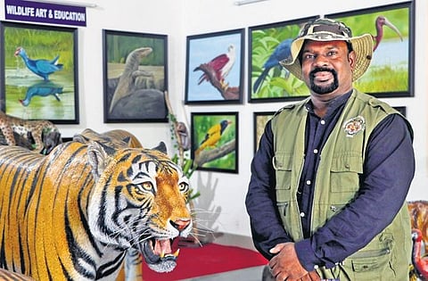 M Bubesh Guptha, founder of Universal Eco Foundation, posing next to the life-sized tiger at the Arts and Crafts Village in Puducherry | sriram r