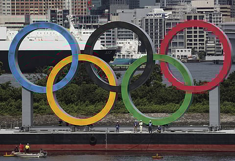 Workers prepare to remove giant Olympic rings from the waterfront area at Odaiba Marine Park after 2020 Summer Olympics came to an end. (Photo | AP)