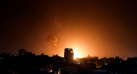Fire and smoke rise above buildings in Gaza City as Israel launched air strikes on the Palestinian enclave. ()Photo | AFP)