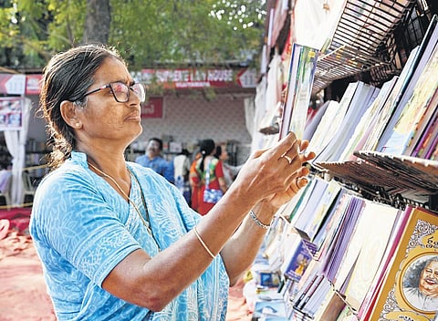 An elderly woman taking look at a book in the 33rd Vijayawada Book Festival on Sunday at Government Polytechnic College Grounds I express