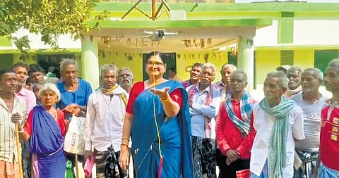 Sarpanch Saroj Devi Agrawal using the drone to deliver pension in front of villagers