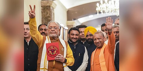 UP CM Yogi Adityanath with Finance Minister Suresh Kumar Khanna flahses the victory sign before presentation of the State Budget 2023-24 in the Assembly, in Lucknow. (Photo | PTI)