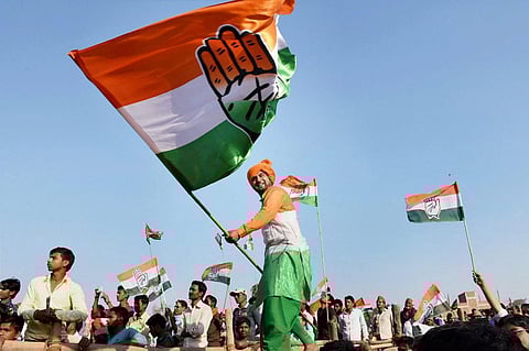 A file photo of a Congress supporter waving the party flag during a rally. (Photo | PTI)