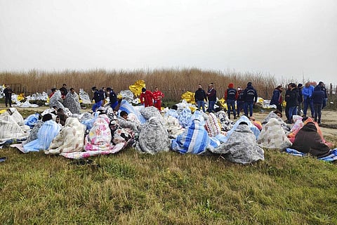 Rescued migrants sit covered in blankets at a beach near Cutro, southern Italy on Feb. 26, 2023 (Photo | AP)