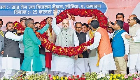 Union Home Minister Amit Shah being garlanded during a public meeting at Lauria in West Champaran district on Saturday. (Photo | PTI)