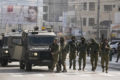 Israeli soldiers take up positions at the scene of a Palestinian shooting attack on an Israeli car at the Hawara checkpoint, near the West Bank city of Nablus, Sunday, Feb. 26, 2023. (Photo | AP)