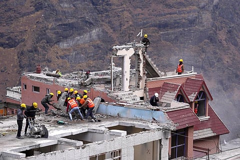 Laborers demolish a building which has developed cracks in Joshimath, in India's Himalayan mountain state of Uttarakhand, Jan. 19, 2023. (Photo | AP)