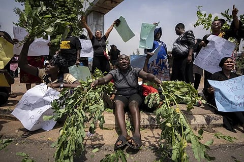 A woman beats branches on the ground as she and other demonstrators protest accusing the election commission of irregularities in downtown Abuja, Feb. 28, 2023. (Photo | AP)