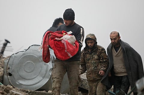 A Syrian man carries the body of an infant who was killed in an earthquake in the town of Jandaris, in the rebel-held part of Aleppo province, on Feb 6, 2023. (Photo | AFP)