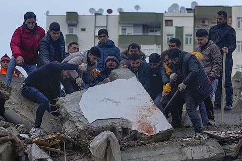 Men search for people among the debris in a destroyed building in Adana, Turkey, Monday, Feb. 6, 2023. (Photo | AP)
