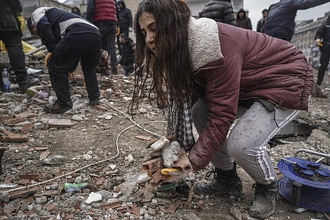 A young women removes debris from a destroyed building as she searches for people with emergency teams in Gaziantep, Turkey (Photo | AP)