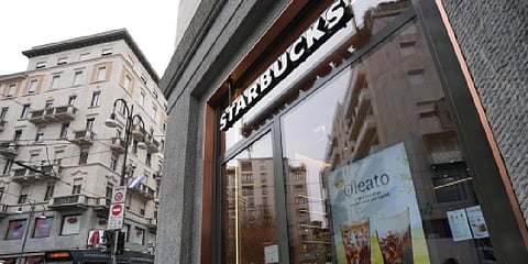 A Starbucks sign advertises the company's Oleato coffee in one of their coffee shops in Milan. (Photo | AP)