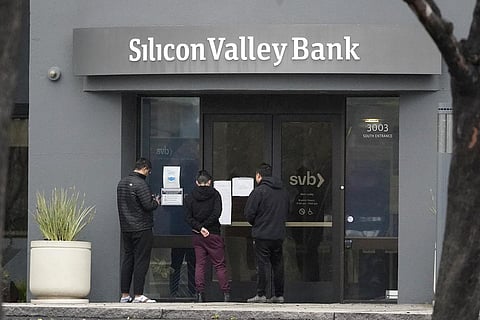 People look at signs posted outside of an entrance to Silicon Valley Bank in Santa Clara, California. (Photo | AP)