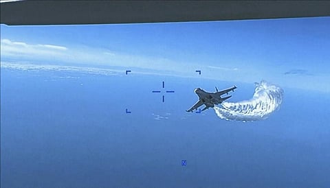The image shows a Russian Su-27 approaching the back of the MQ-9 drone and beginning to release fuel as it passes, over the Black Sea.(Photo | AP)