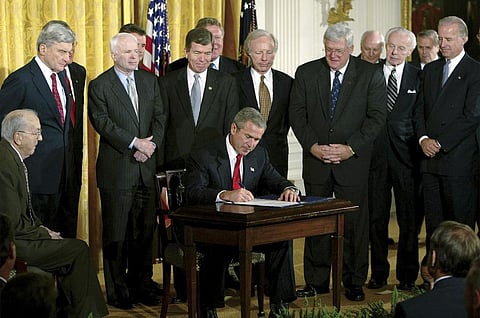 Ex-US President George W Bush signs a resolution authorizing the use of force against Iraq, on Oct. 16, 2002. (File Photo | AP)