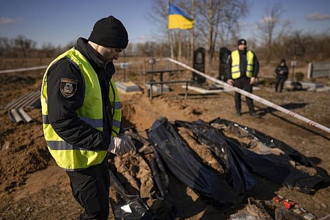 Police officers stand next to three freshly exhumed bodies in a cemetery on the outskirts of Borodyanka, Ukraine, Thursday, March 2, 2023. (Photo | AP)