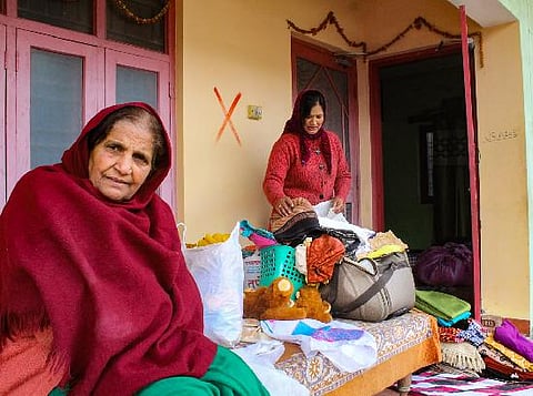 Residents shift their belongings from an 'unsafe' building at the land subsidence affected area in Joshimath. (Photo | PTI)