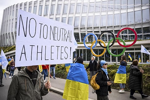 Members of the Geneva branch of Ukrainian society in Switzerland protest during a rally to urge International Olympic Committee in reconsidering the participation of Russian athletes. (Photo | AP)