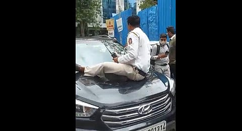 Representational image: A screengrab from a video showing a traffic police constable being dragged on the bonnet of a car...