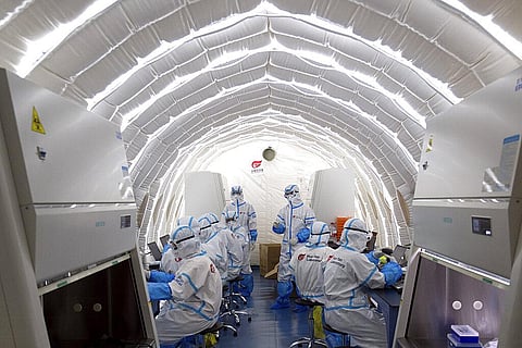 File photo released by China's Xinhua News Agency, staff members work in an inflatable COVID-19 testing lab provided by Chinese biotech company BGI Genomics, a subsidiary of BGI Group (Photo |AP)