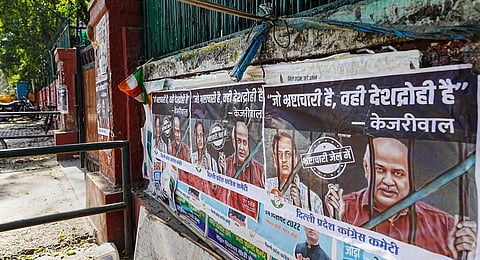 Posters of AAP leaders Manish Sisodia and Satyendar Jain put up outside Congress headquarters, in New Delhi. (Photo | PTI)