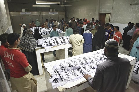 People gather around the bodies of the victims of stampede, at a morgue in Karachi, Pakistan on Friday, March 31, 2023. (Photo | AP)