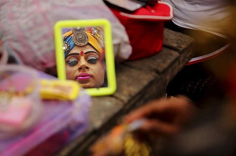 FILE: An artist looks in a mirror backstage as she prepares for a religious procession on Ram Navami in New Delhi. (Photo | AP)