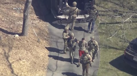 This image made from video provided by WCVB-TV, shows Jack Teixeira, in T-shirt and shorts, being taken into custody by armed tactical agents on Thursday, April 13, 2023, in Dighton, Mass. (Photo | AP