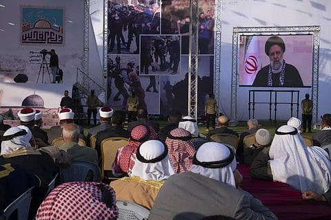 Palestinians watch a pre-recorded speech by Iranian President Ebrahim Raisi on 'Jerusalem Day,' at a soccer filed in Gaza City, April 14, 2023. (Photo | AP)