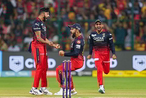 Royal Challengers Bangalore bowler Mohammed Siraj celebrates with teammate Virat Kohli after taking the wicket of Chennai Super Kings batter Ruturaj Gaikwad. (Photo | PTI)