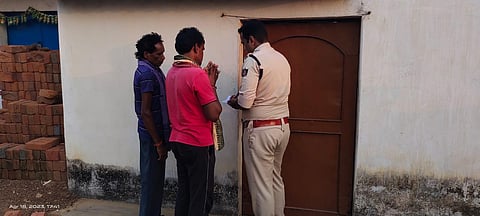 A policeman trying to open the door of house in which the bodies were found | Express