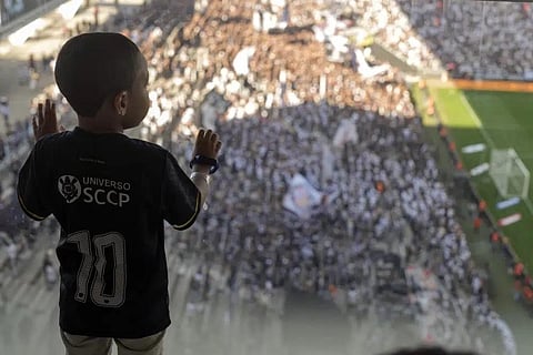Five-years-old Arthur Alves, with autism spectrum disorder, watches a Brazilian championship match in a special isolated room where noise impacts less, at the Neo Quimica Arena. (Photo | AP)