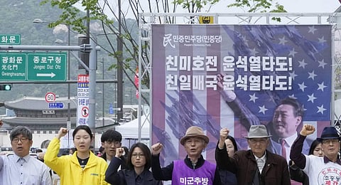 Protesters with a banner showing an image of South Korean President Yoon Suk Yeol stage a rally to denounce policies of the United States and South Korea on North Korea near the U.S. Embassy. (AP)