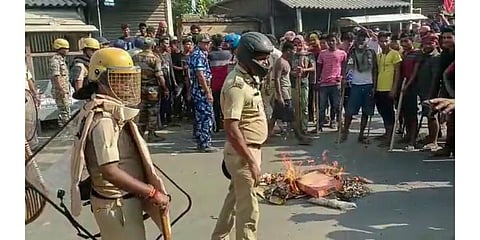 Security personnel try to control the situation after violent protests by locals over the death of a minor girl, in North Dinajpur district of West Bengal. (Photo | PTI)