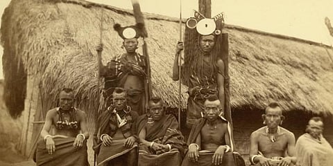 A group portratit of Tanghkhul Naga men pictured in front of a settlement. (Photo | Pitt Rivers Museum)
