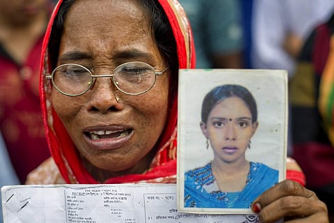A Bangladeshi woman cries holding a portrait of her daughter who was a victim of the Rana Plaza garment factory collapse, on the fifth anniversary of the accident in Savar, near Dhaka. (File Ph