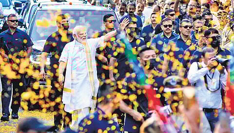 Prime Minister Narendra Modi waves at the crowd as he walks through a street in Thevara during a roadshow in Kochi on Monday | A Sanesh