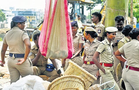 A child sleeping in hammock comforted by a police personnel during the eviction process at Mayor Ramanathan Salai in Chetpet on Tuesday | P Ravikumar
