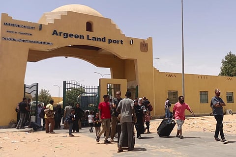 Evacuees carry their luggages as they cross into Egypt through the Argeen land port, after being evacuated from Sudan to escape the conflict. (Photo | AP)