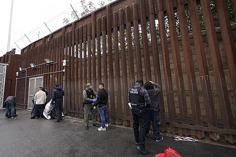 FILE - Federal officers remove handcuffs from men before releasing them through a gate in a border wall to Tijuana, Mexico, Wednesday, March 15, 2023, in San Diego. (Photo | AP)