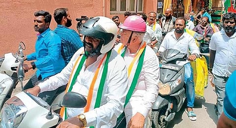 KPCC working president Ramalinga Reddy rides pillion on a scooter during a campaign in Bengaluru on Thursday. (Photo | Express)