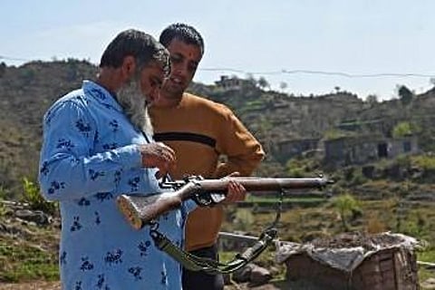 Civil servant Sanjeet Kumar (R) listens to a retired Indian army soldier Abdul Qayoom at Dhangri village in India's administered Kashmir. (Photo | AFP)