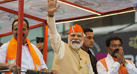 Narendra Modi waves at crowd during a roadshow in support of BJP candidates for upcoming Assembly polls, in Bengaluru, Saturday, April 29, 2023. (PTI Photo)