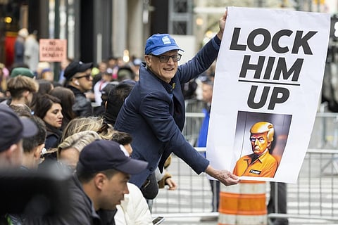 A protester holds a placard outside Trump Tower in New York on Monday, April 3, 2023. (Photo | AP)