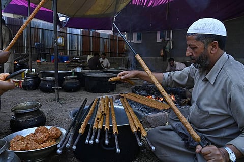 In this photo taken on September 15, 2019, chefs prepare long kebabs made from minced meat ahead of a traditional feast. (Tauseef Mustafa | AFP)