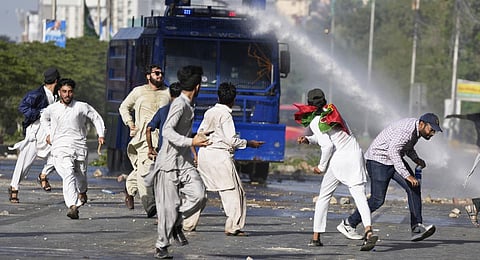 Police use a water cannon to disperse supporters of Pakistan's former PM Imran Khan protesting against the arrest of their leader, in Karachi, Pakistan, Tuesday, May 9, 2023.(Photo | PTI)