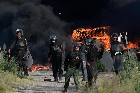 Police officers throw stones towards supporters of Pakistan's former Prime Minister Imran Khan during clashes in Islamabad (Photo | AP)