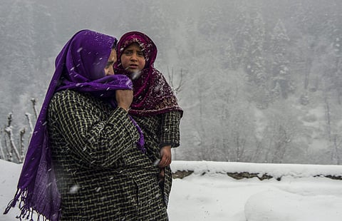 FILE: (Representational Image) A woman walks with her child at a village covered with a white blanket of snow. (Photo | PTI)