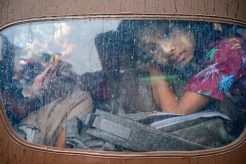 A girl looks out from a tuk tuk while evacuating in Sittwe on May 13, 2023. ( Photo | AFP )